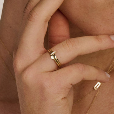14k geelgouden aanschuifring Luna om vinger heen gedragen in combinatie met een ring met diamanten
